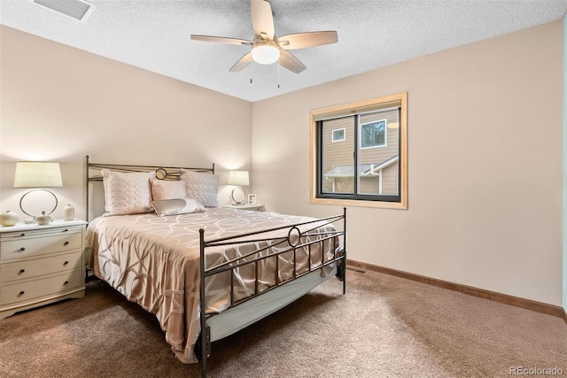 bedroom with ceiling fan, carpet flooring, and a textured ceiling