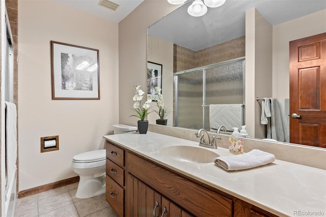 bathroom featuring tile patterned floors, vanity, toilet, and a shower with door