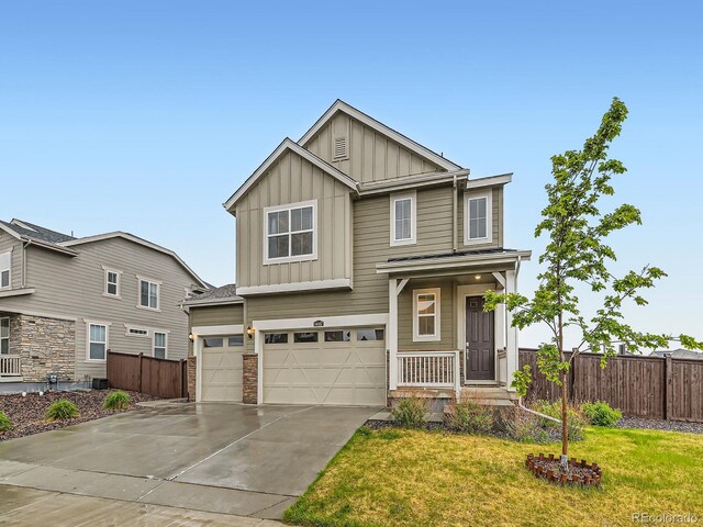 view of front of house with board and batten siding, concrete driveway, an attached garage, and stone siding