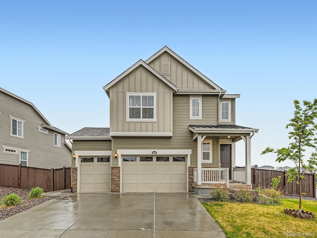 craftsman house with board and batten siding, covered porch, driveway, and stone siding