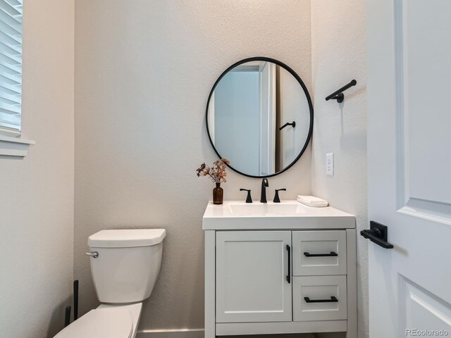 half bathroom with vanity and toilet