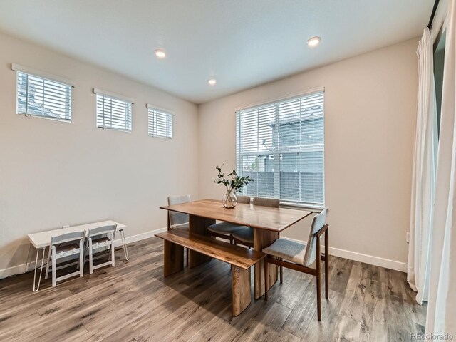 dining room with baseboards, wood finished floors, and recessed lighting