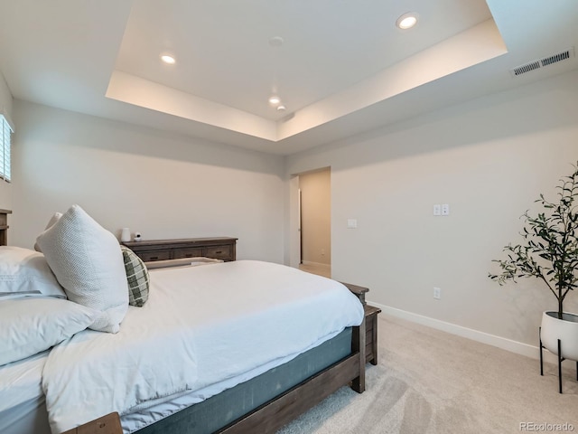 bedroom featuring a raised ceiling, light colored carpet, recessed lighting, and baseboards