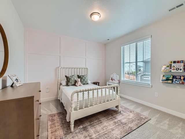 bedroom featuring light carpet and baseboards