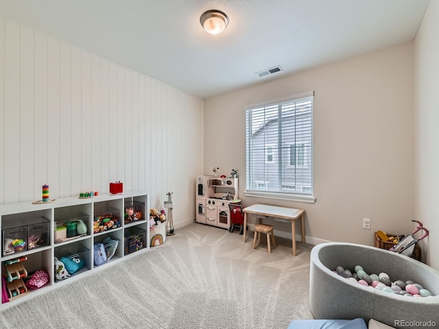 recreation room with baseboards and carpet