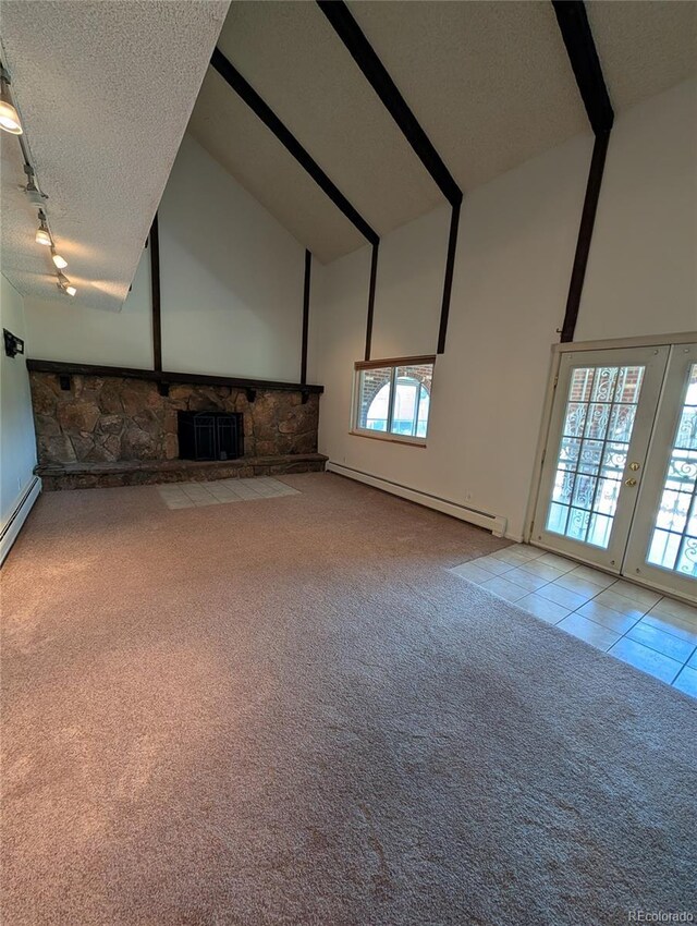 unfurnished living room with a baseboard radiator, high vaulted ceiling, carpet flooring, track lighting, and a textured ceiling