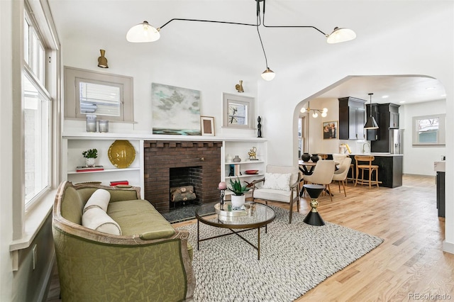 living room with hardwood / wood-style flooring and a brick fireplace