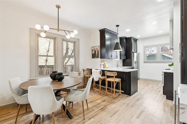 dining room featuring sink and light wood-type flooring