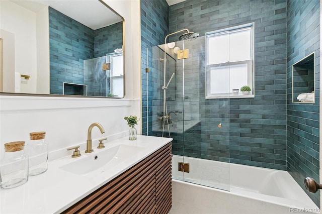 bathroom featuring combined bath / shower with glass door, vanity, and a healthy amount of sunlight