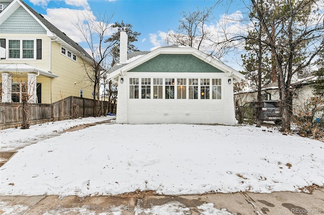 snow covered property featuring a garage and an outbuilding