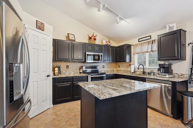 23634 Broadmoor Dr, Parker, CO 80138 - kitchen with stainless steel appliances, track lighting, vaulted ceiling, light tile patterned floors, and a center island