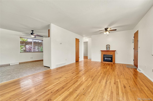 3490 Mowry Pl, Westminster, CO 80031 - unfurnished living room with ceiling fan, light wood-type flooring, and a fireplace