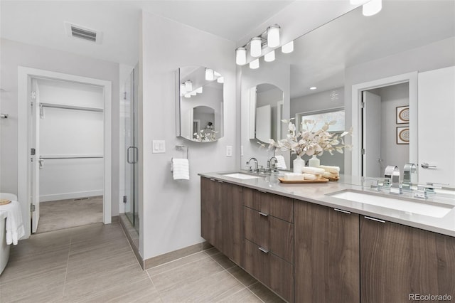 full bathroom featuring double vanity, a sink, visible vents, and a shower stall