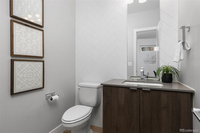 bathroom with toilet, vanity, and tile walls