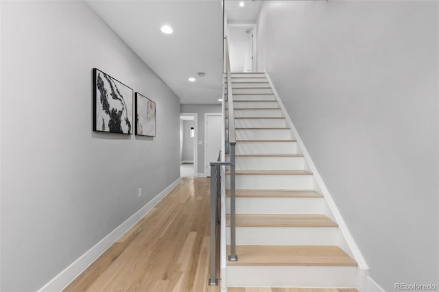 stairway with recessed lighting, wood finished floors, and baseboards