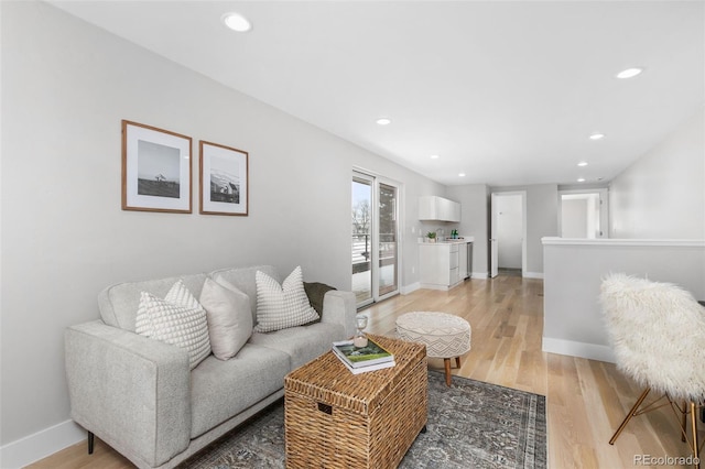 living room featuring recessed lighting, baseboards, and wood finished floors