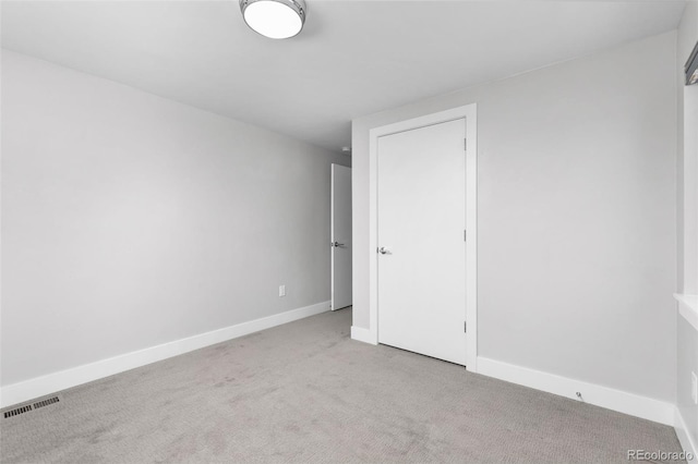 unfurnished bedroom with visible vents, light colored carpet, and baseboards