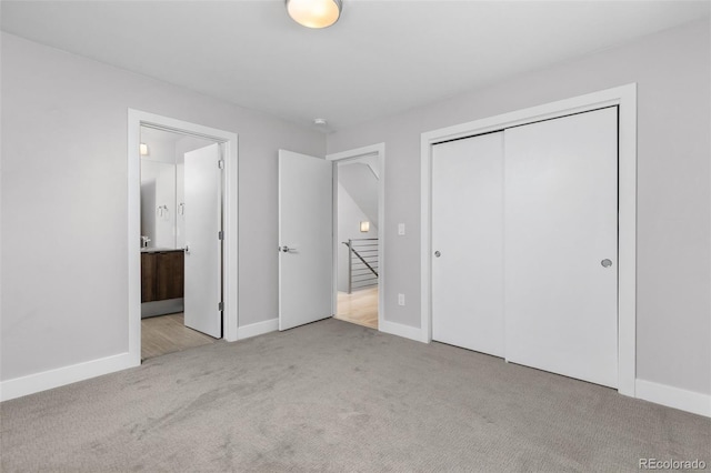 unfurnished bedroom featuring light carpet, a closet, and baseboards