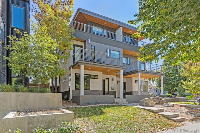 modern home featuring a balcony and stucco siding