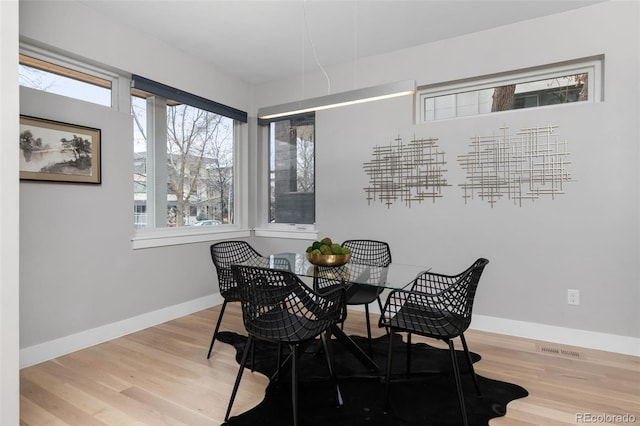 dining area featuring wood finished floors, visible vents, and baseboards