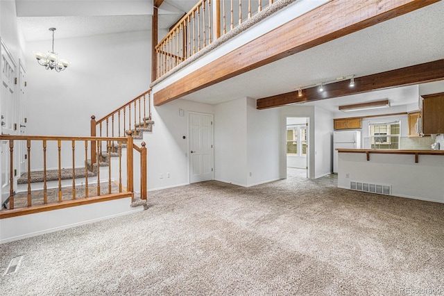 1915 S Hannibal St Unit G, Aurora, CO 80013 - unfurnished living room featuring a chandelier, carpet, stairway, baseboards, and beam ceiling