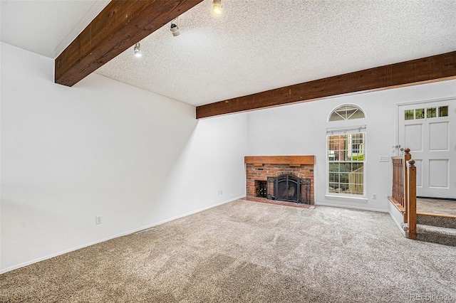 1915 S Hannibal St Unit G, Aurora, CO 80013 - unfurnished living room featuring beam ceiling, carpet floors, track lighting, a brick fireplace, and a textured ceiling