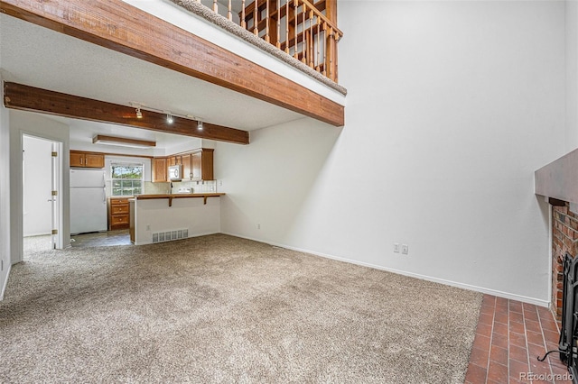 1915 S Hannibal St Unit G, Aurora, CO 80013 - unfurnished living room with baseboards, rail lighting, dark colored carpet, and beam ceiling