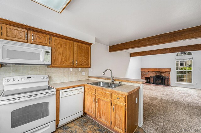 1915 S Hannibal St Unit G, Aurora, CO 80013 - kitchen featuring white appliances, a sink, a peninsula, decorative backsplash, and a brick fireplace
