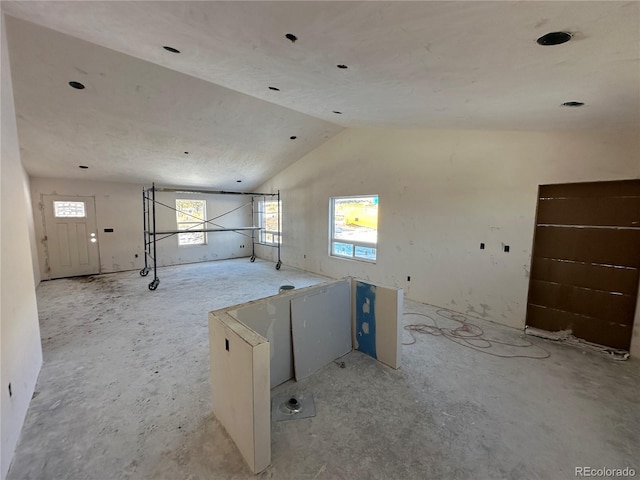 unfurnished room featuring lofted ceiling