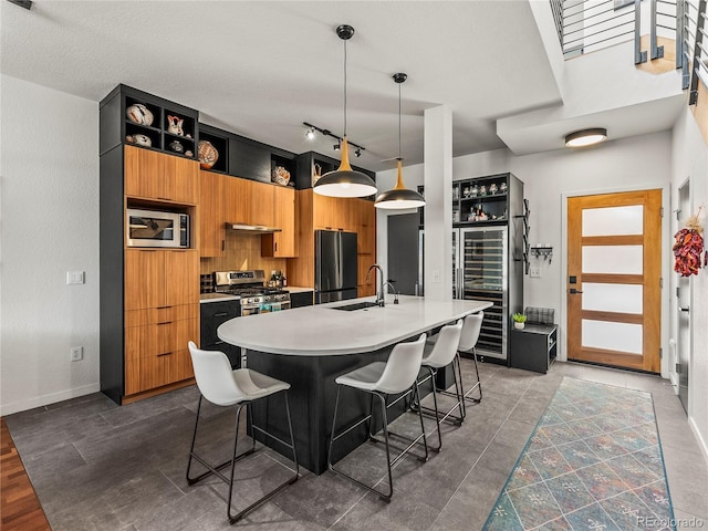 3133 Blake St Unit 3, Denver, CO 80205 - kitchen with appliances with stainless steel finishes, a sink, light countertops, an island with sink, and open shelves
