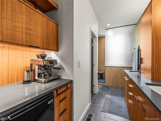 3133 Blake St Unit 3, Denver, CO 80205 - kitchen with brown cabinets, dishwasher, modern cabinets, dark countertops, and dark tile patterned floors