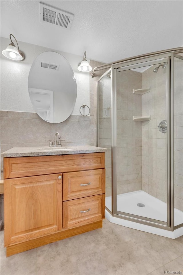 1250 Acropolis Dr, Lafayette, CO 80026 - full bath with a stall shower, tile walls, vanity, a textured ceiling, and tile patterned floors
