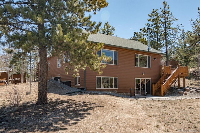 rear view of house featuring stairs and a deck