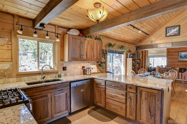 kitchen featuring a peninsula, lofted ceiling with beams, a sink, wood ceiling, and stainless steel dishwasher