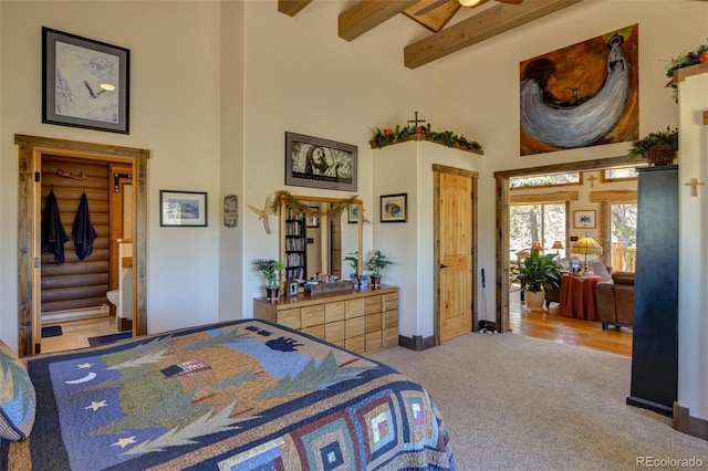 bedroom featuring beamed ceiling, carpet flooring, a high ceiling, and rustic walls