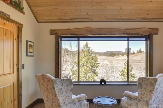 sitting room with a mountain view, wooden ceiling, and vaulted ceiling