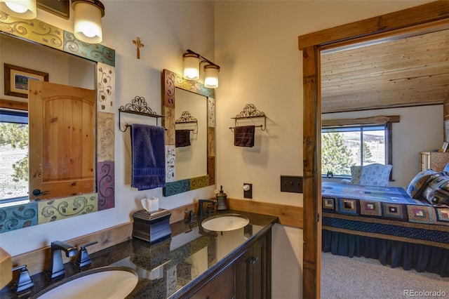 ensuite bathroom with a sink, double vanity, ensuite bathroom, and vaulted ceiling