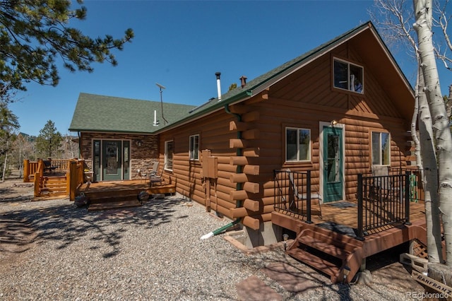 exterior space with log siding and a deck