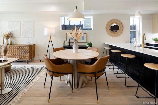 dining room featuring sink and light hardwood / wood-style flooring