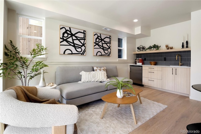 living room featuring light hardwood / wood-style flooring and wet bar