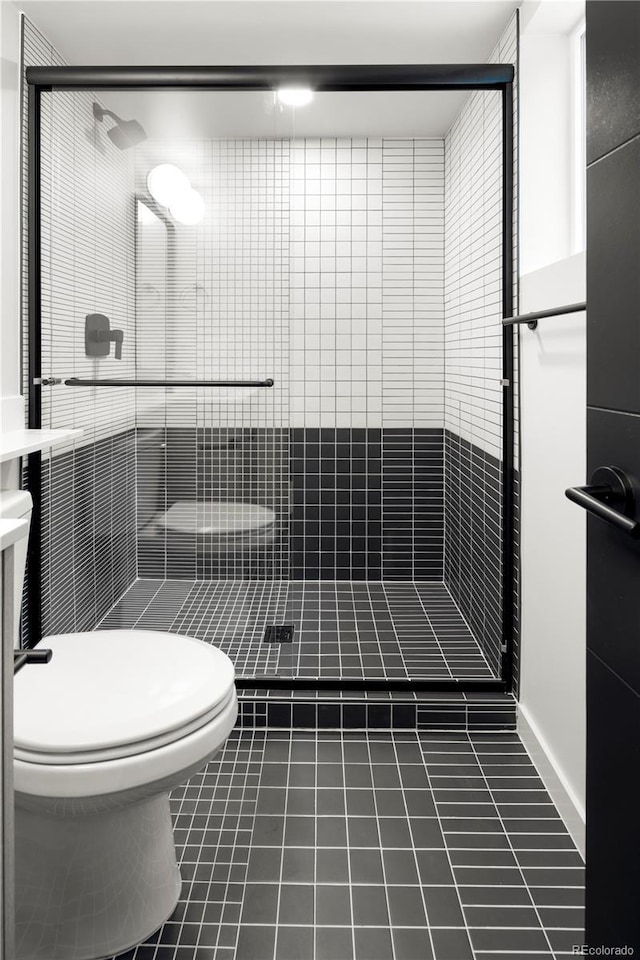 bathroom featuring an enclosed shower, tile patterned floors, and toilet