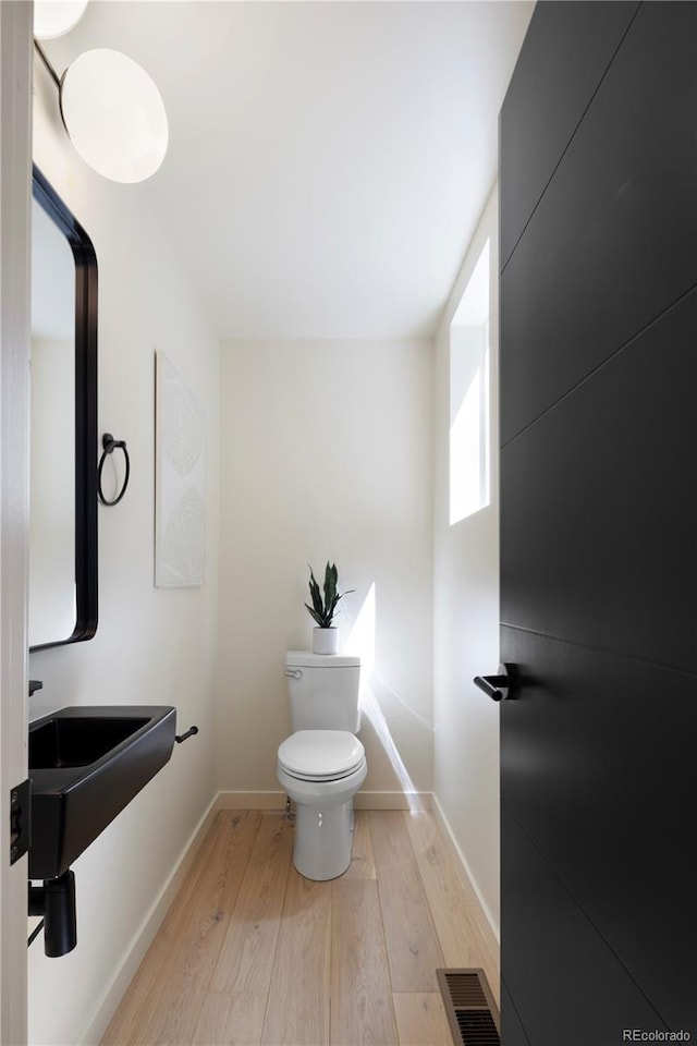 bathroom featuring hardwood / wood-style floors and toilet