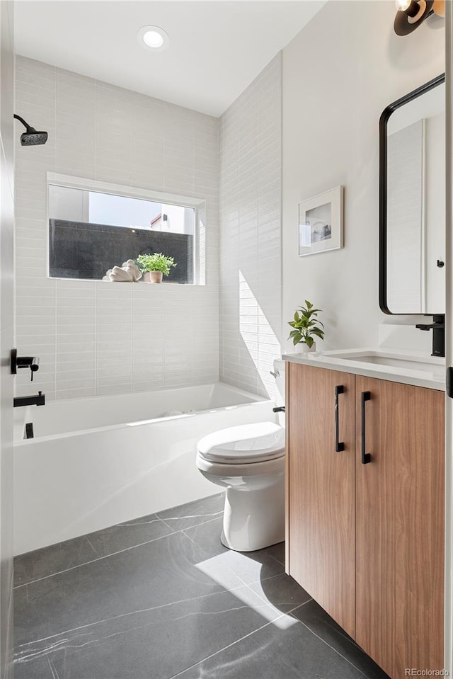 full bathroom featuring vanity, tile patterned flooring, toilet, and tiled shower / bath