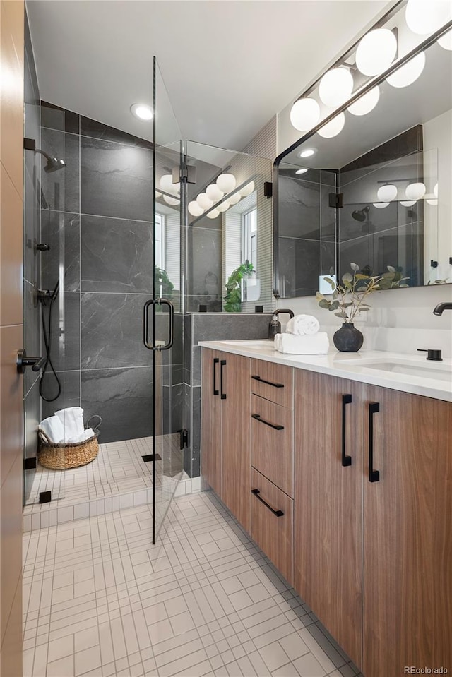 bathroom with tile patterned flooring, vanity, and a shower with door