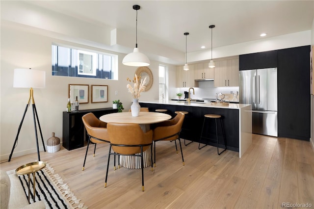 dining room with sink and light wood-type flooring