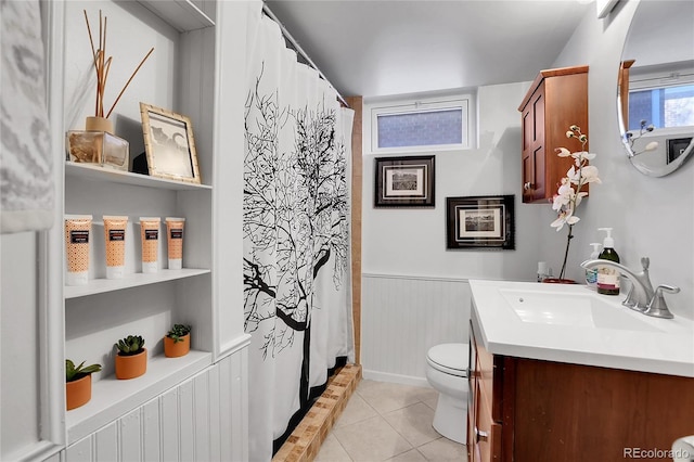 bathroom with tile patterned flooring, vanity, toilet, and walk in shower