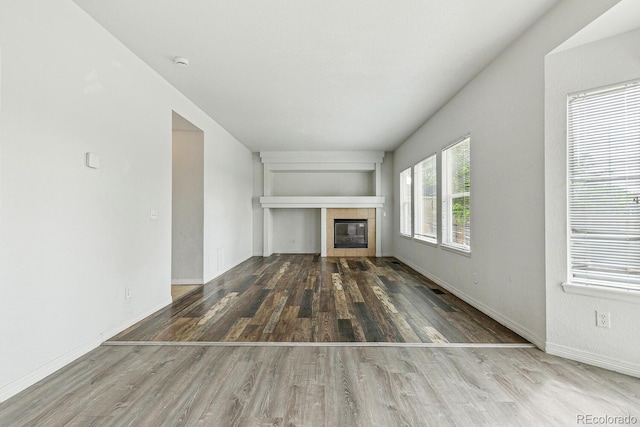 15762 Olmsted Pl, Denver, CO 80239 - unfurnished living room featuring wood finished floors, a fireplace, baseboards, and built in shelves