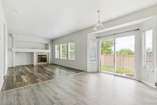 15762 Olmsted Pl, Denver, CO 80239 - unfurnished living room featuring wood finished floors, baseboards, and a fireplace