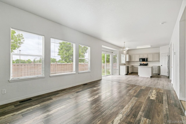 15762 Olmsted Pl, Denver, CO 80239 - unfurnished living room with hardwood / wood-style flooring and baseboards