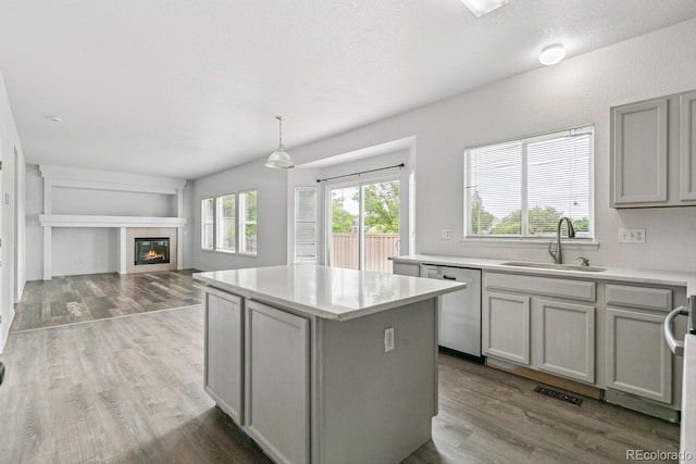 15762 Olmsted Pl, Denver, CO 80239 - kitchen with dishwasher, a sink, gray cabinets, a kitchen island, and light countertops